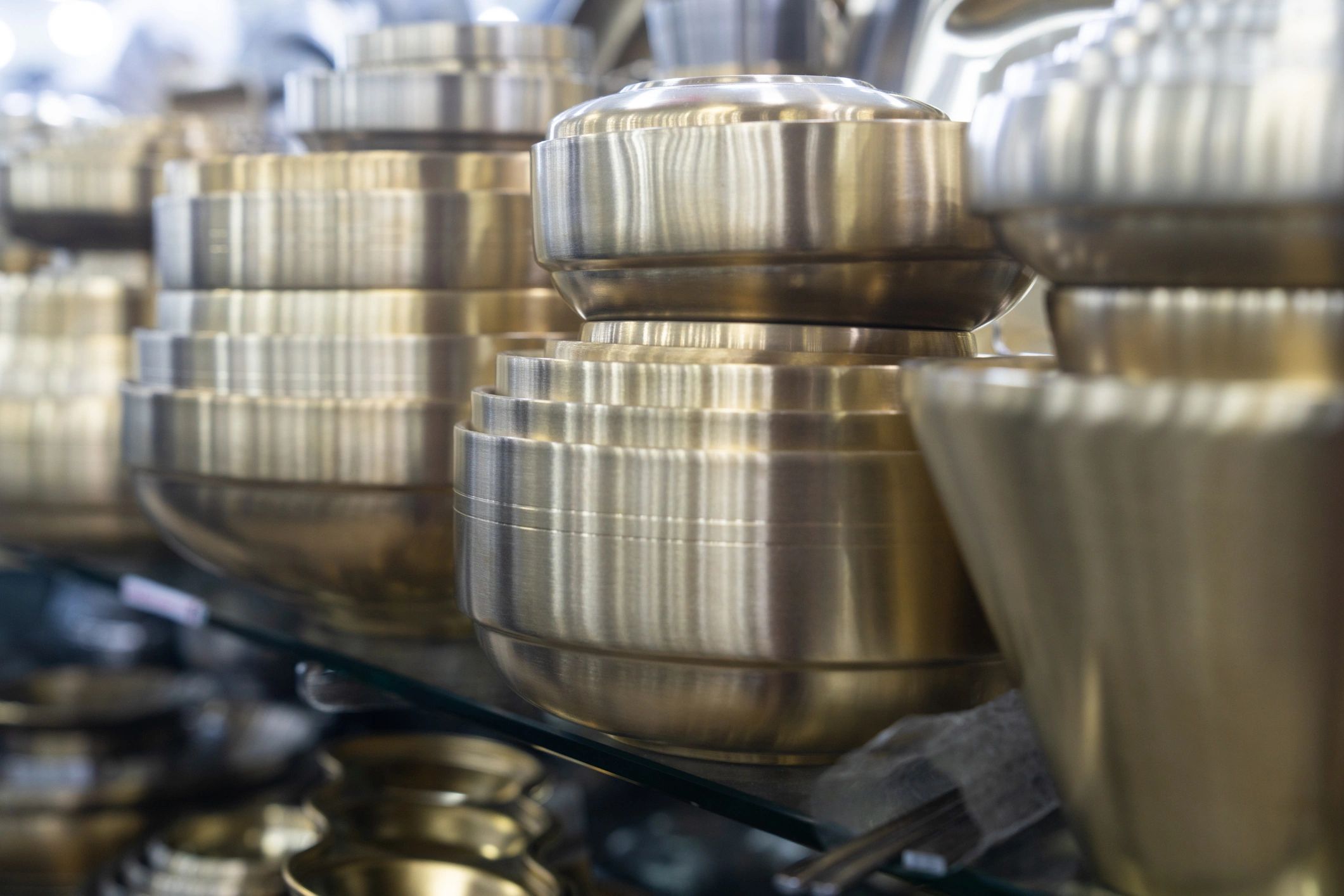 Assorted metal bowls and dishes displayed in a market setting